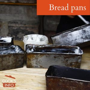 Bread pans being greased
