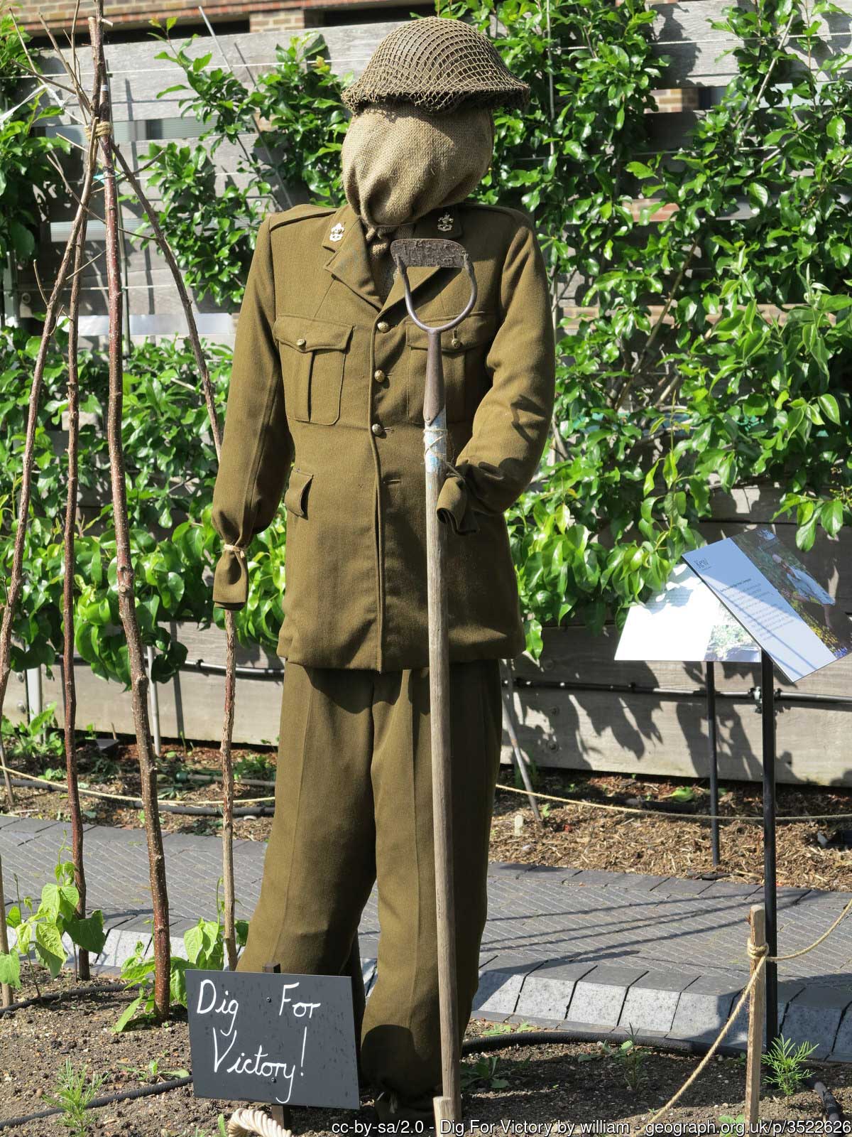 Solider mannequin digging in a garden