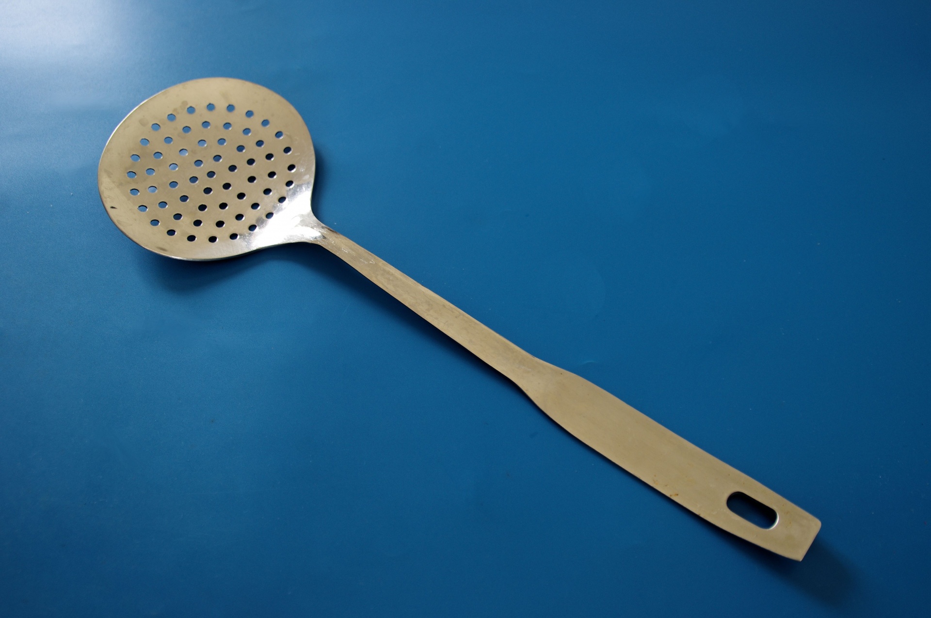 Slotted spoon with flat bowl
